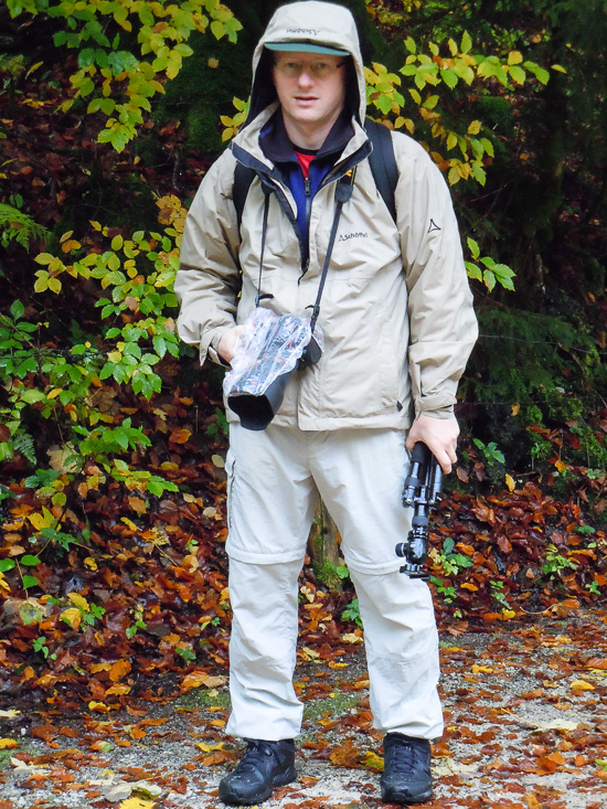 Fotograf mit Ausrüstung und Regenschutz